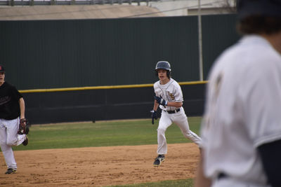 Teen boy running bases at baseball game 