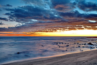 Scenic view of beach against sky during sunset