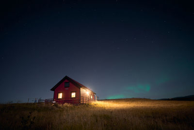 House on field against sky at night