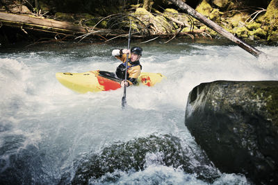 Confident man kayaking in river
