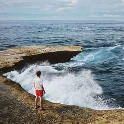 Rear view of boy standing on beach