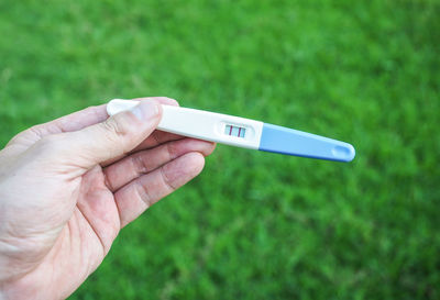 Close-up of hand holding grass