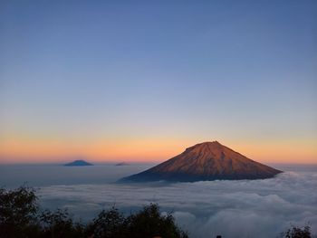 Scenic view of volcanic mountain against sky during sunset