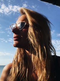 Portrait of woman with sunglasses against sky