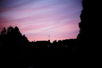 Silhouette trees against sky at sunset