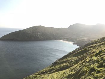 Scenic view of sea and mountains against clear sky