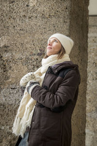 Side view of woman in warm clothing looking up