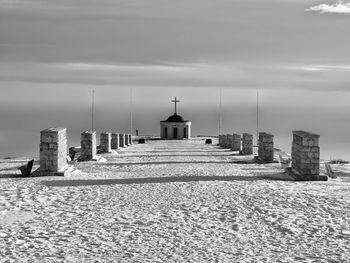 Snow covered built structure against sky