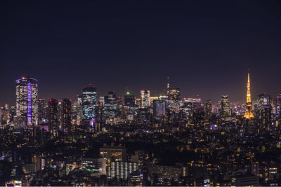 Illuminated buildings in city against sky at night