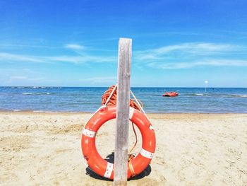 Wooden posts on beach against sky