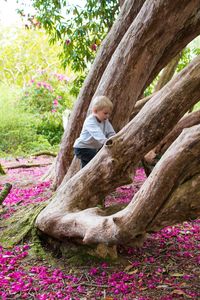 Girl sitting on tree trunk