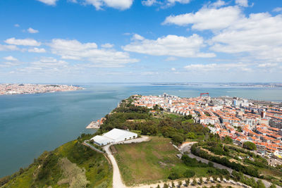 High angle view of townscape by sea against sky