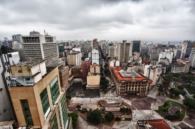 View of cityscape against cloudy sky