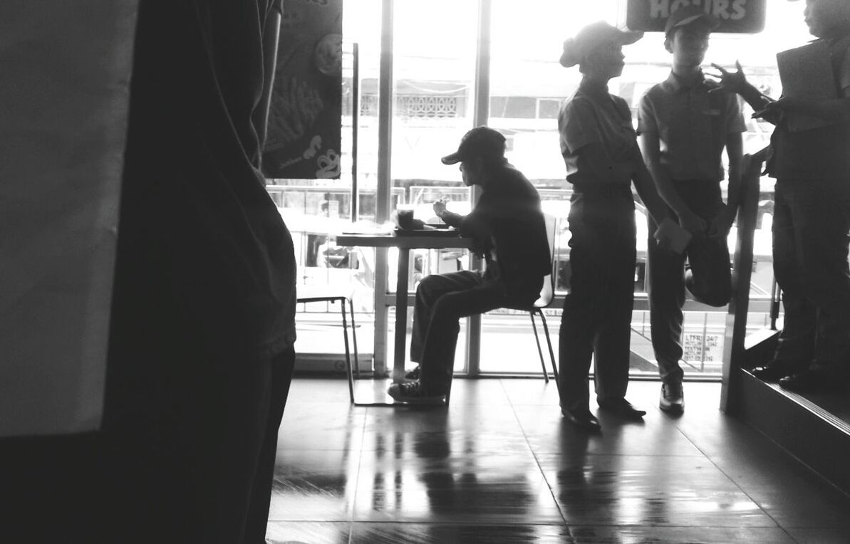 REAR VIEW OF WOMAN SITTING ON WALL