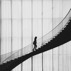 Full length of woman walking on suspension bridge