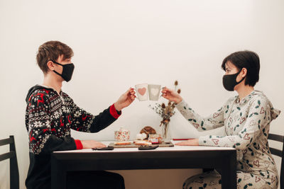 Side view of woman using mobile phone while sitting at home