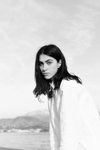 Portrait of woman standing against sky