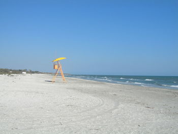 Scenic view of beach against clear blue sky