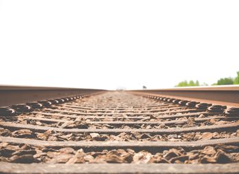 Surface level of rusty railroad tracks against clear sky