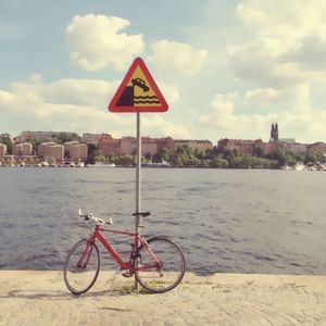 Road sign against cloudy sky