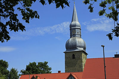 Low angle view of building and trees against sky