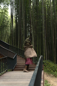 Rear view of woman walking in forest