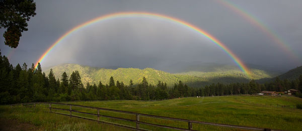 Scenic view of rainbow over landscape against sky