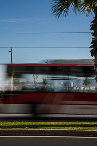 Train at railroad station in city against sky