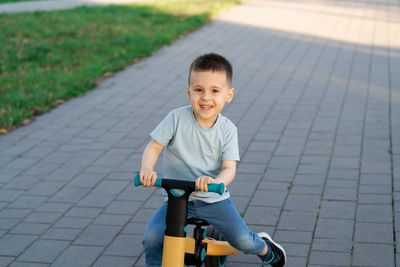 Boy riding bicycle on footpath