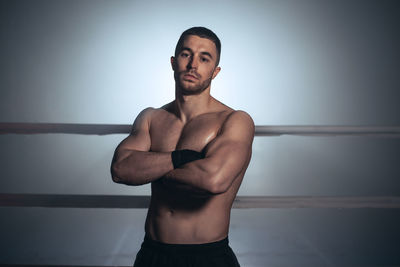 Shirtless man standing at boxing ring