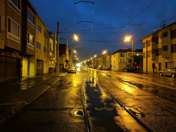 View of road along buildings at night