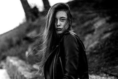 Portrait of beautiful woman standing against tree