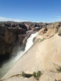 Scenic view of waterfall against sky