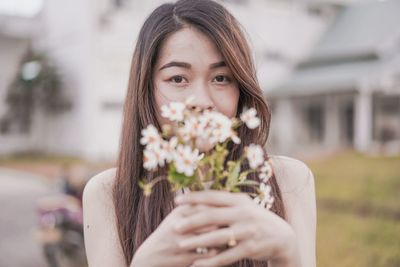 Portrait of woman holding red flower