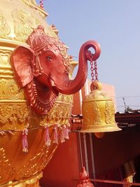 Low angle view of statue against temple against sky