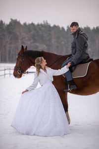 Full length of young woman riding horse