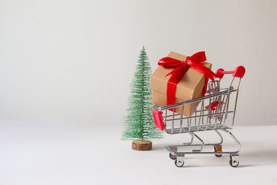 Close-up of miniature shopping cart against white background