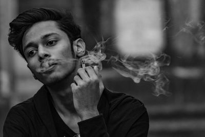 Portrait of young man smoking cigarette