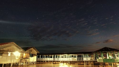 Houses by sea against sky at night