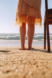 Low section of woman standing on beach