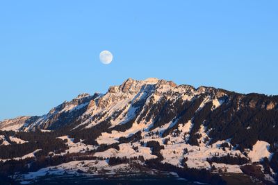 Scenic view of snowcapped mountains against clear blue sky