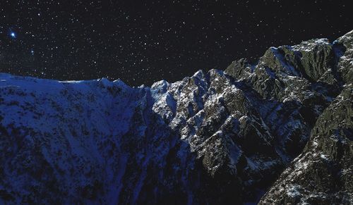 Close-up of snow on mountain against sky at night