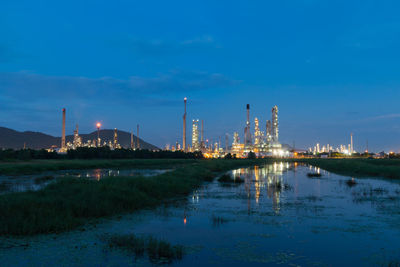 Illuminated factory against sky at night