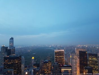 Illuminated cityscape against sky at night