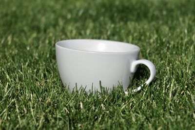 Close-up of coffee cup on grass
