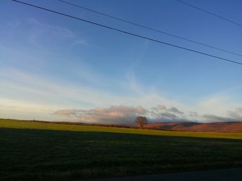 Scenic view of field against cloudy sky