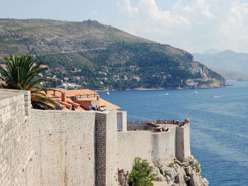 High angle view of buildings by sea against sky