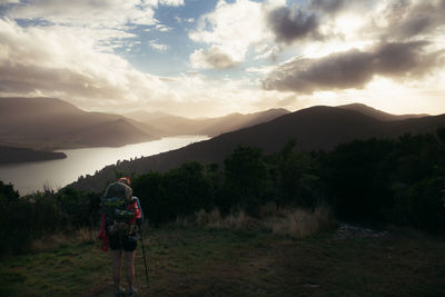 Rear view of person on mountains against sky