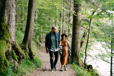 Friends walking on footpath in forest