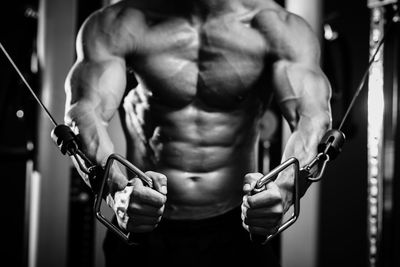 Midsection of muscular man exercising in gym